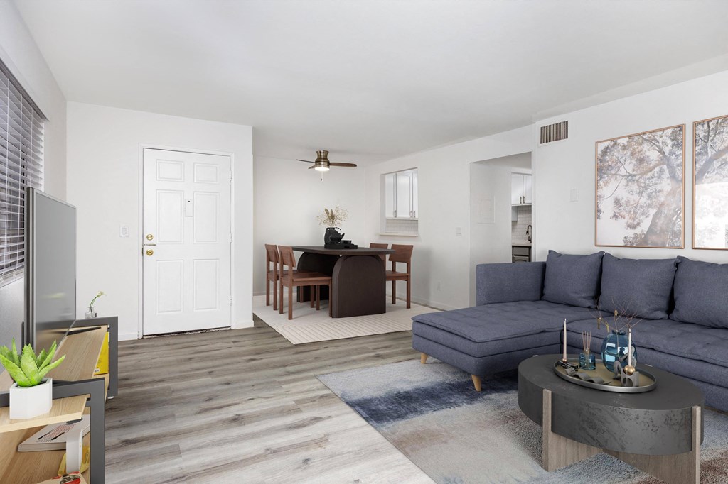 a living room with a blue couch and a dining room