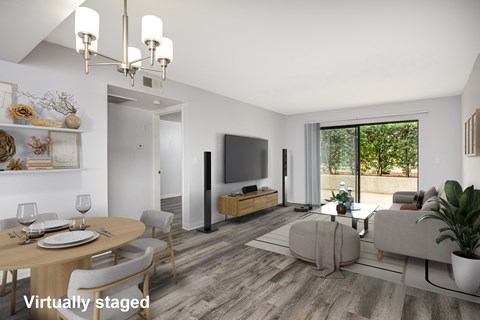A modern living room with a dining table set for two and a flat screen TV.
