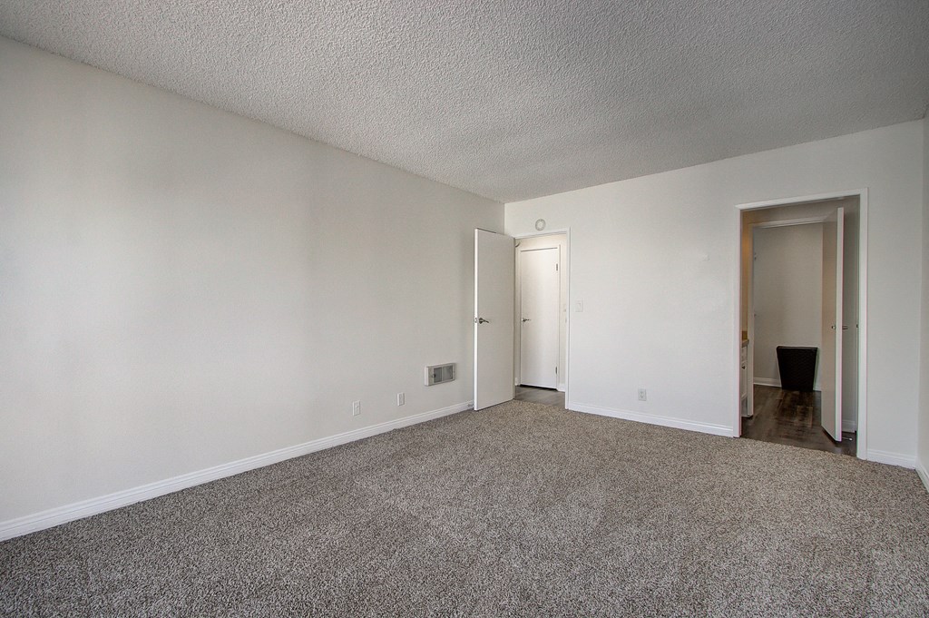 a bedroom with a carpeted floor and white walls
