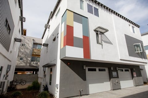 A white building with a red, green, and blue square on the side.