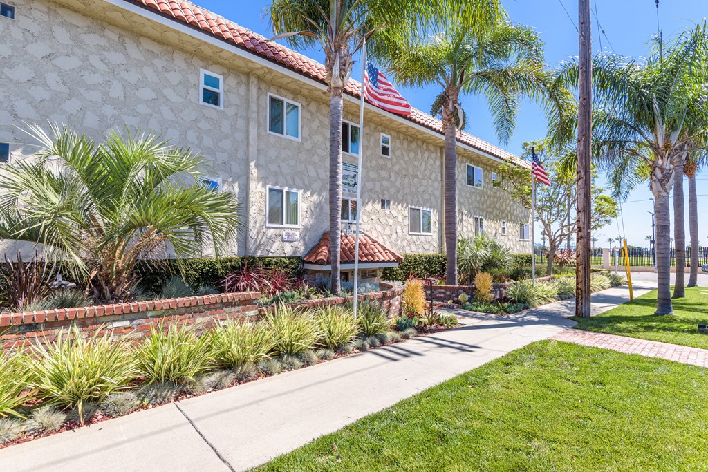 a building with an flag and palm trees in front of it