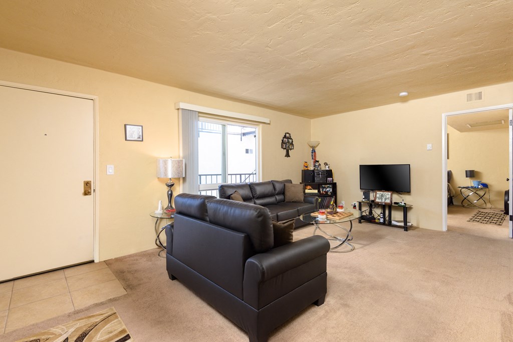 a living room with two leather couches and a tv