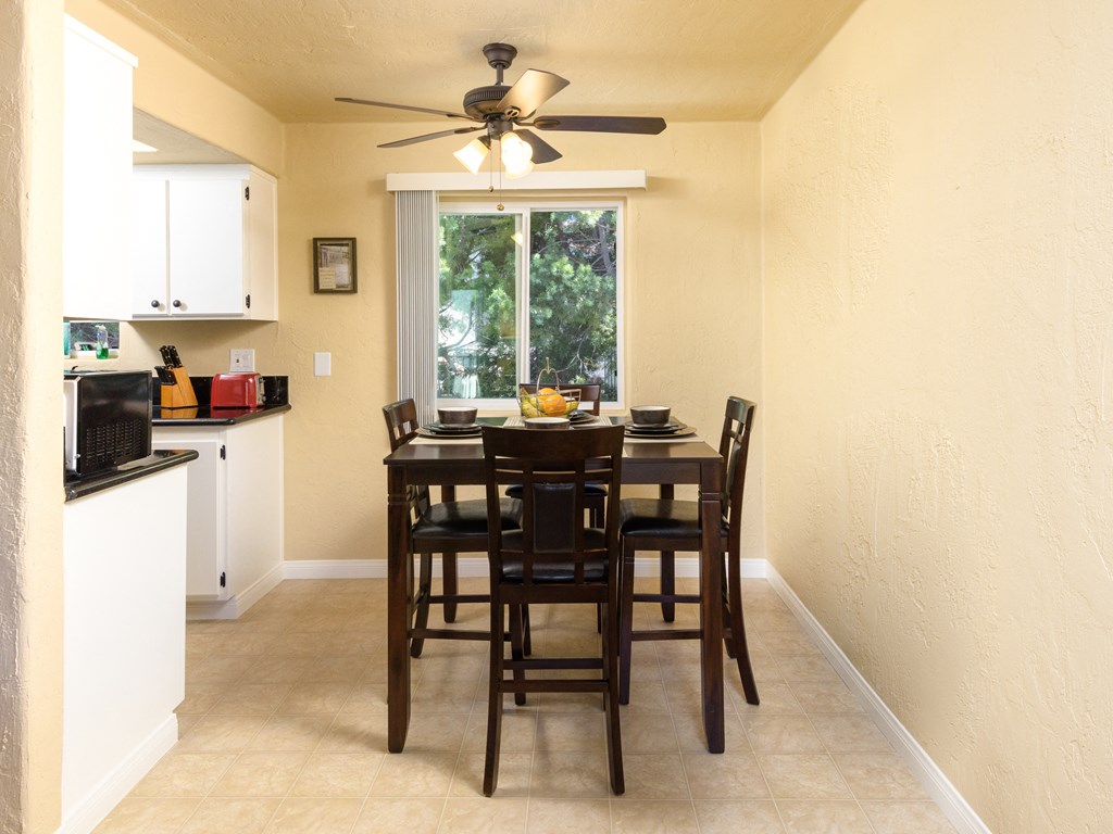 a dining room with a table and chairs and a ceiling fan