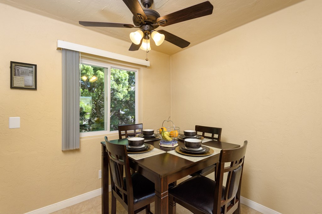 a dining room with a table and chairs and a ceiling fan