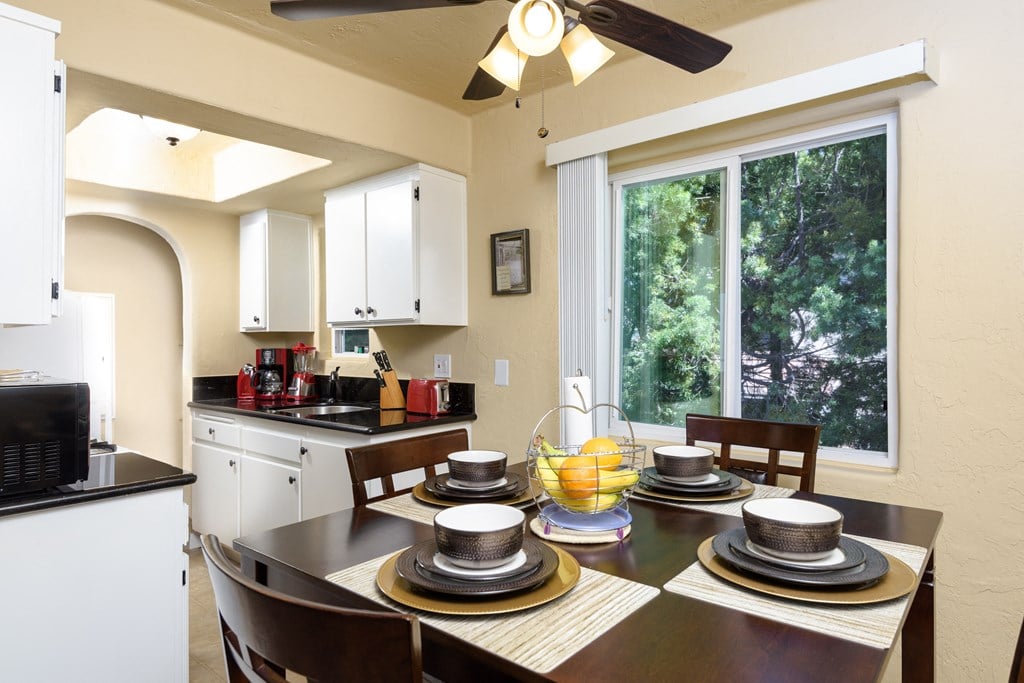 a kitchen and dining room with a table and chairs and a large window