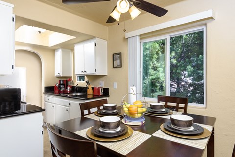 a kitchen and dining room with a table and chairs and a large window