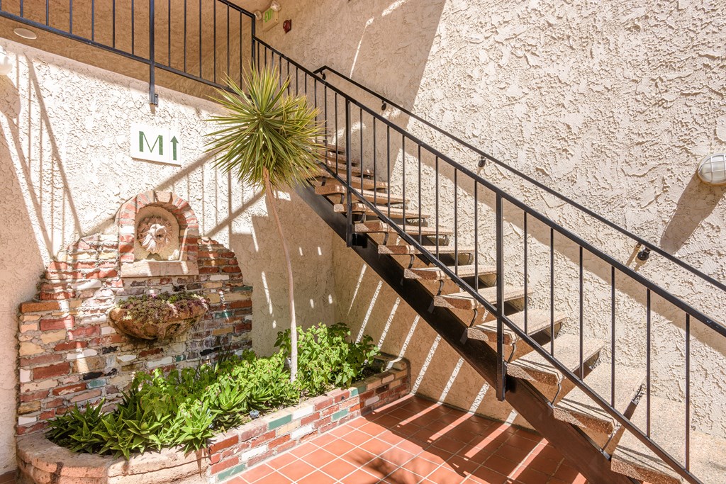 a set of stairs leading up to a building with a plant