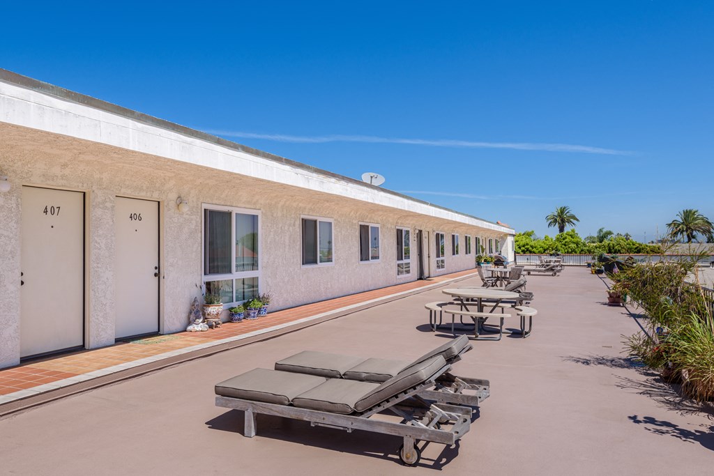 a building with a row of beach chairs and picnic tables