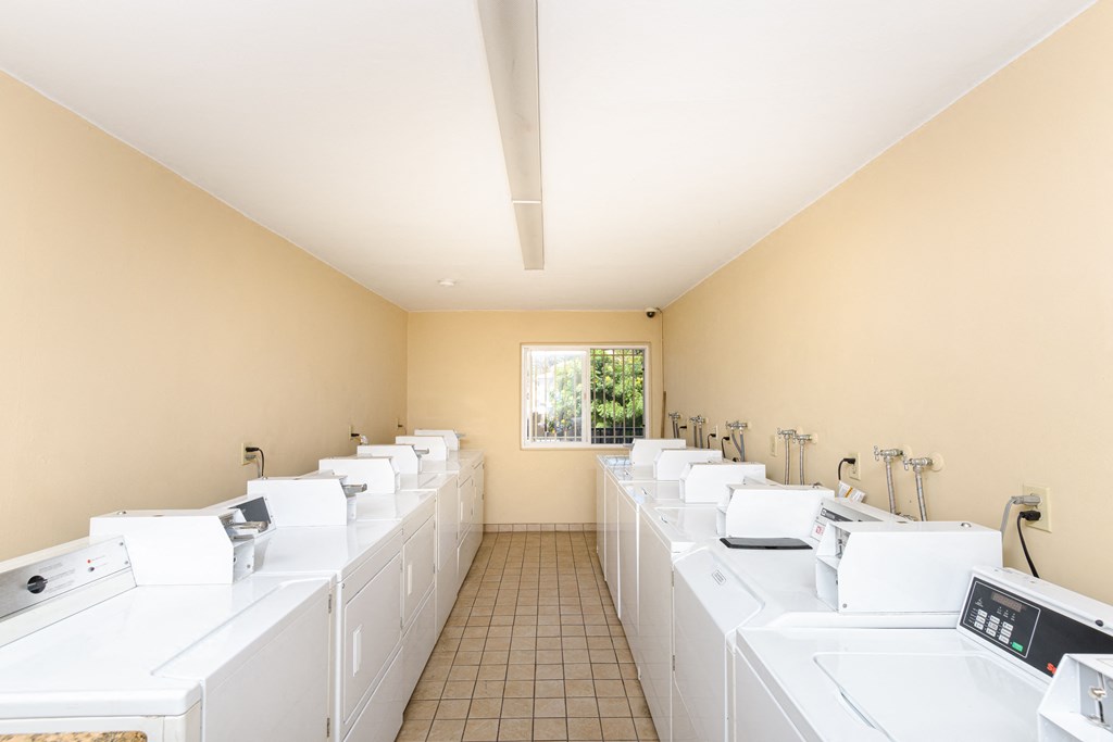 a washer and dryer room with white washing machines