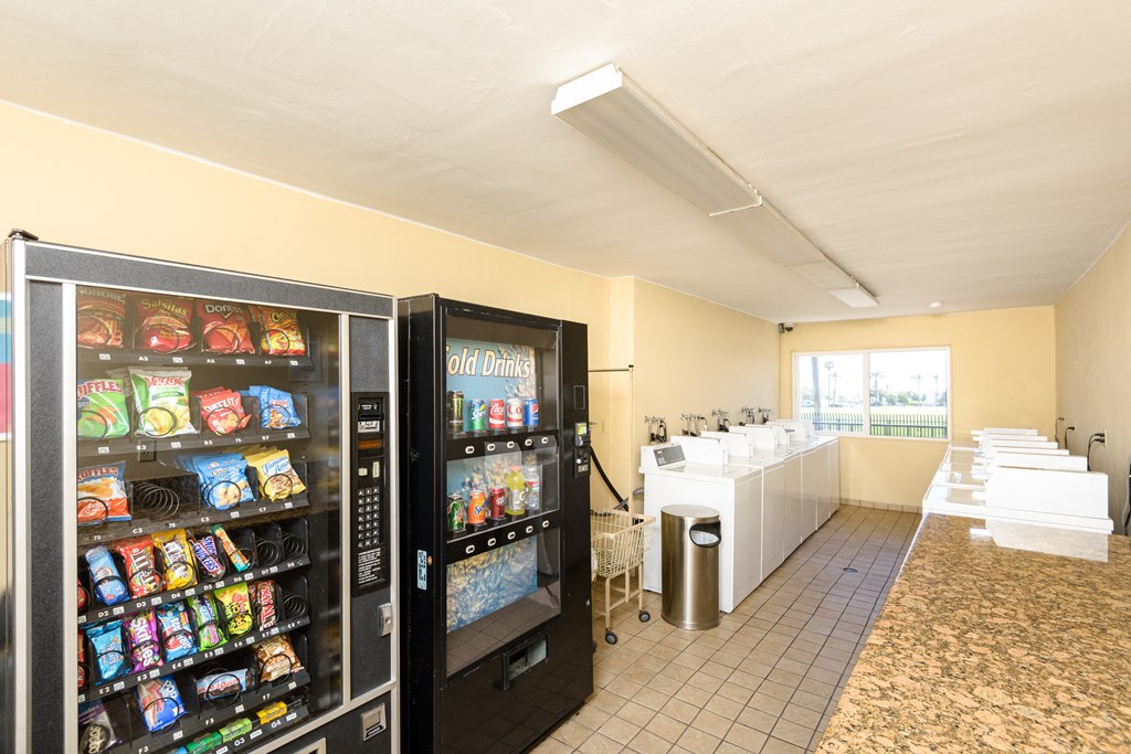 a snack room with two refrigerators and a row of vending machines