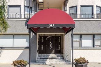 a building with a red awning and a black and white door