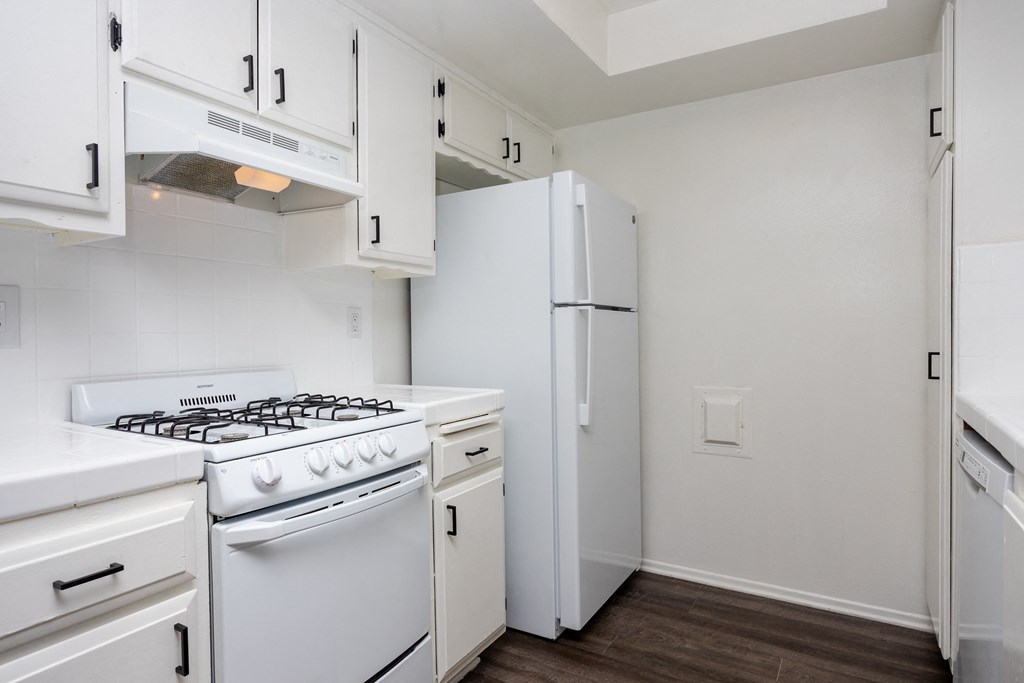 a kitchen with white appliances and white cabinets and a white refrigerator