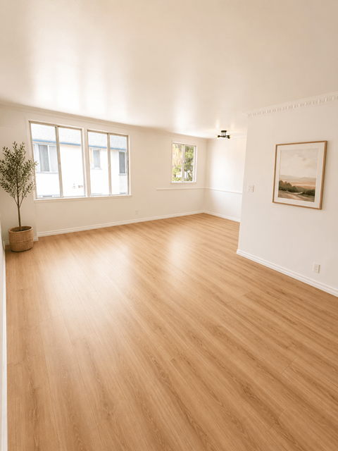 A room with wooden flooring and a painting on the wall.
