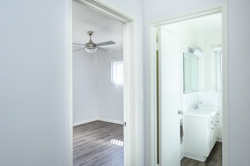 an empty bathroom with a mirror and a ceiling fan