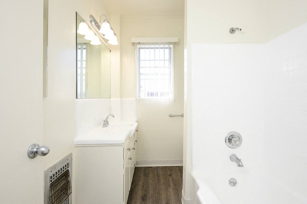 a bathroom with a tub and a sink and a mirror