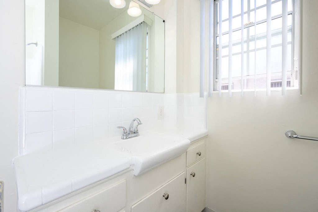 a white bathroom with a sink and a mirror