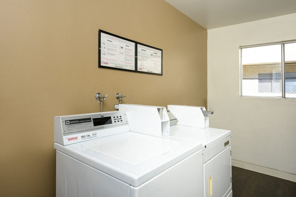 a laundry room with two washing machines and a window