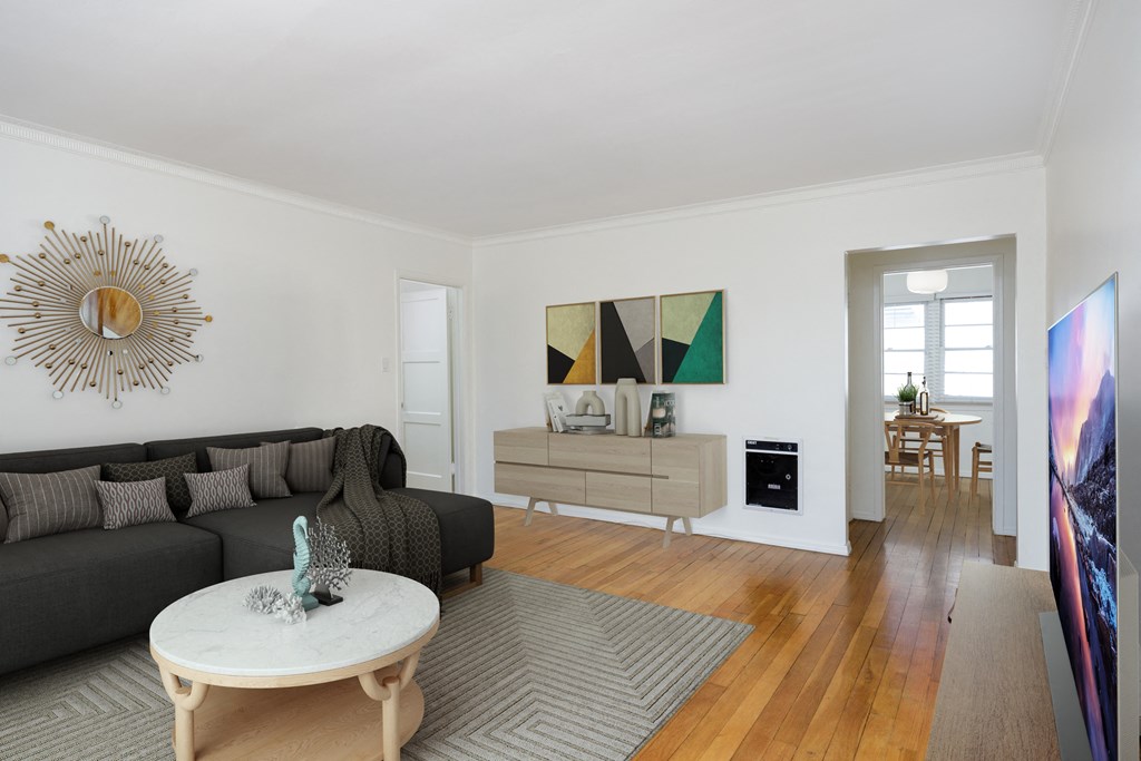 a living room with a black couch and a white table