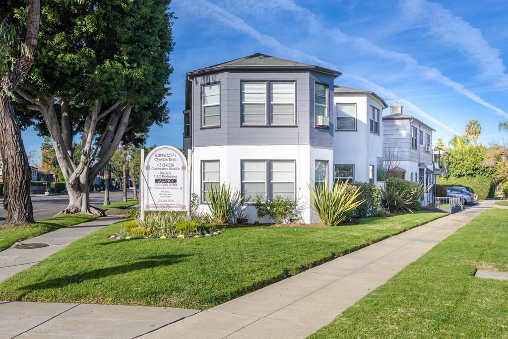 a house with a sidewalk and a sign in front of it