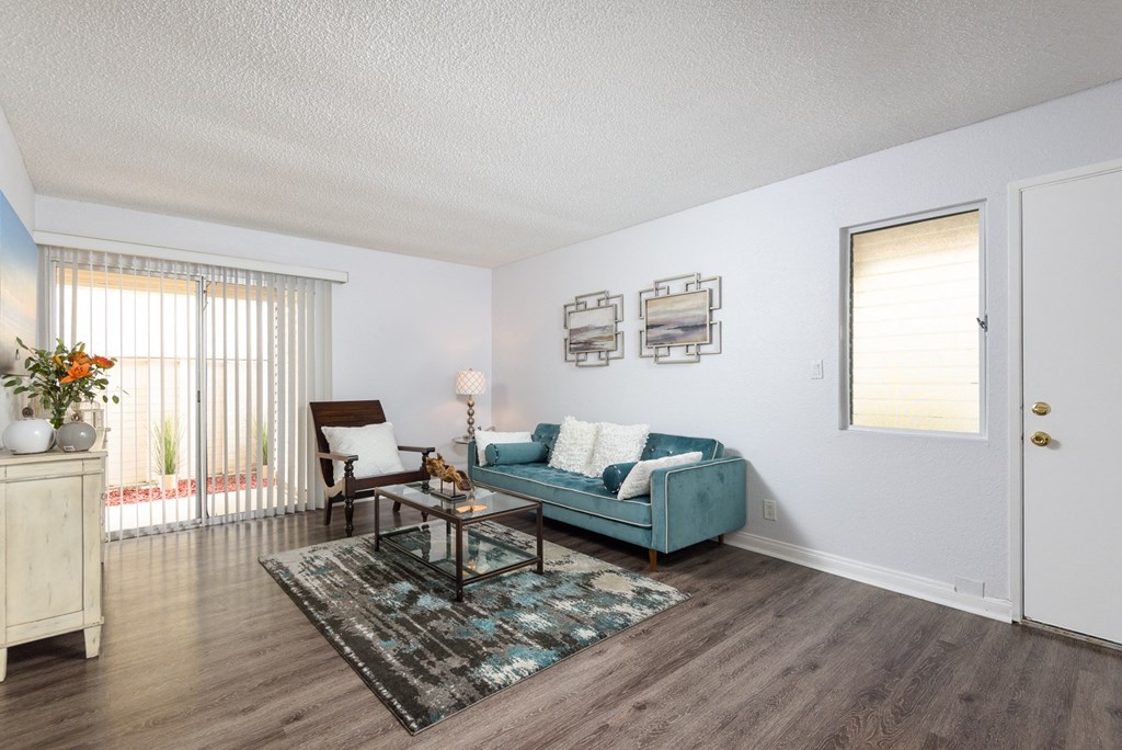 the living room of an apartment with a blue couch and a coffee table