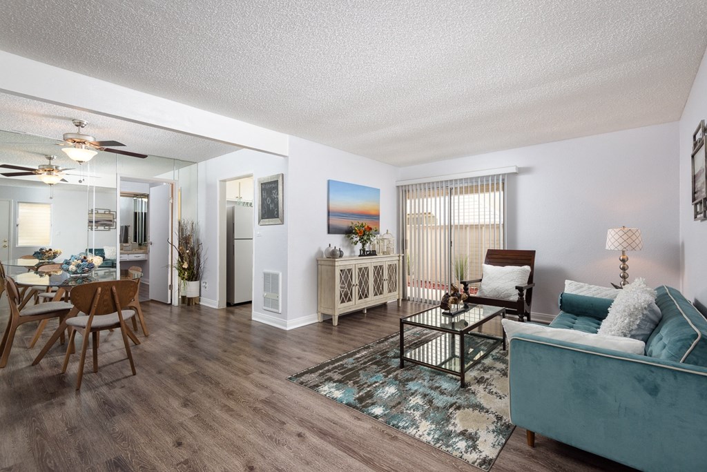 a living room and dining room with hardwood floors and white walls