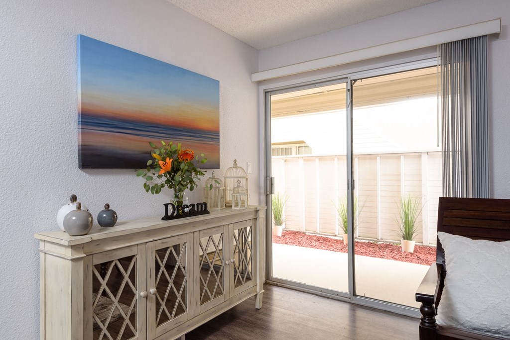 a bedroom with a large painting of a sunset on the wall