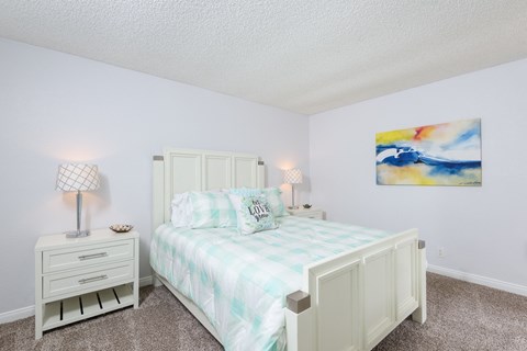 a bedroom with a bed and white cabinets