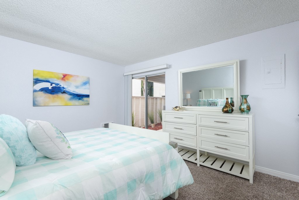 a bedroom with a bed and a dresser and a mirror