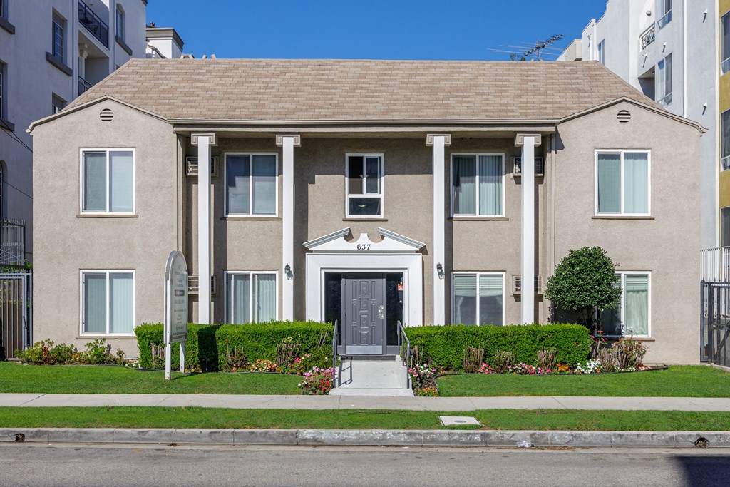 a large house with a sidewalk in front of it