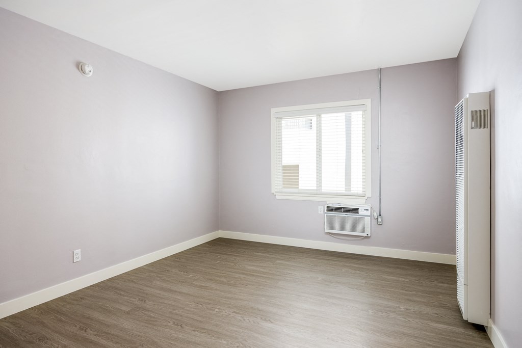 an empty room with a radiator and a window