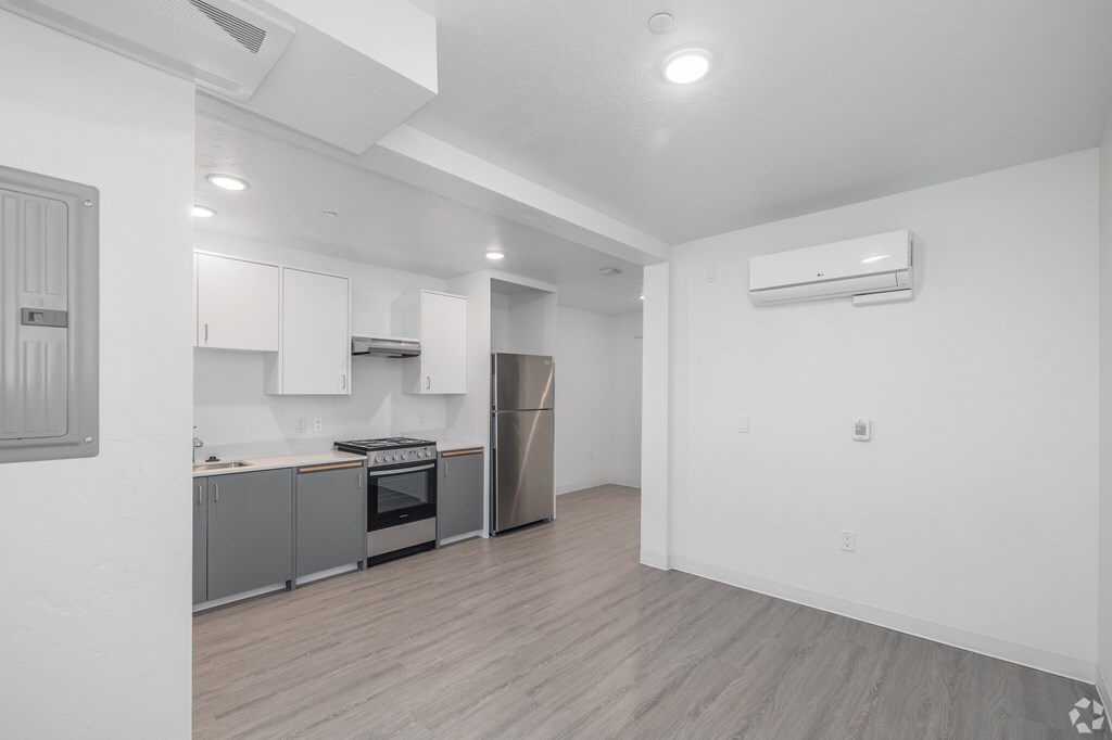 A kitchen with a refrigerator, oven, and cabinets.