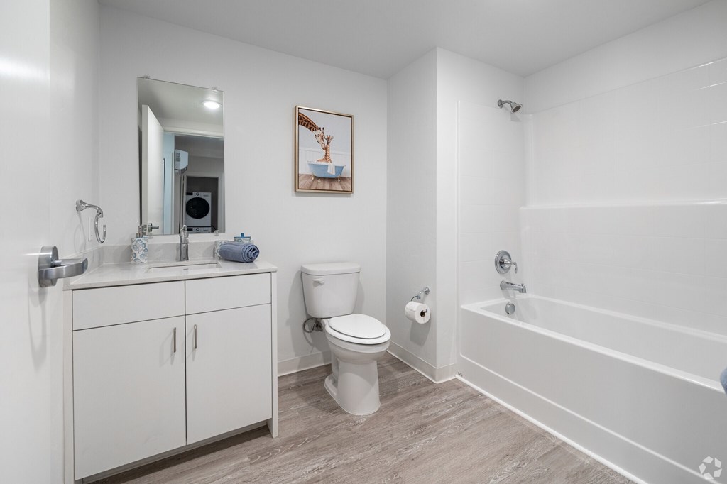 A white bathroom with a toilet, sink, and bathtub.