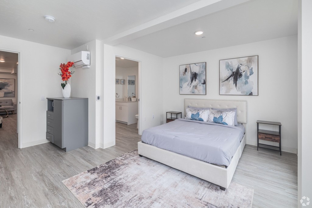 A bedroom with a large bed and a grey cabinet.