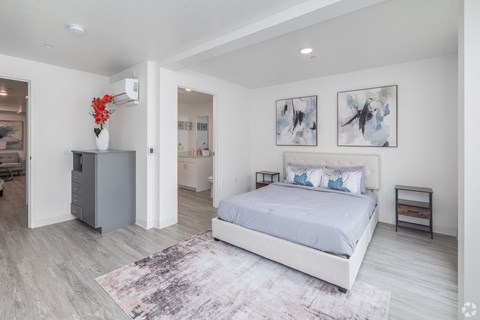 A bedroom with a large bed and a grey cabinet.