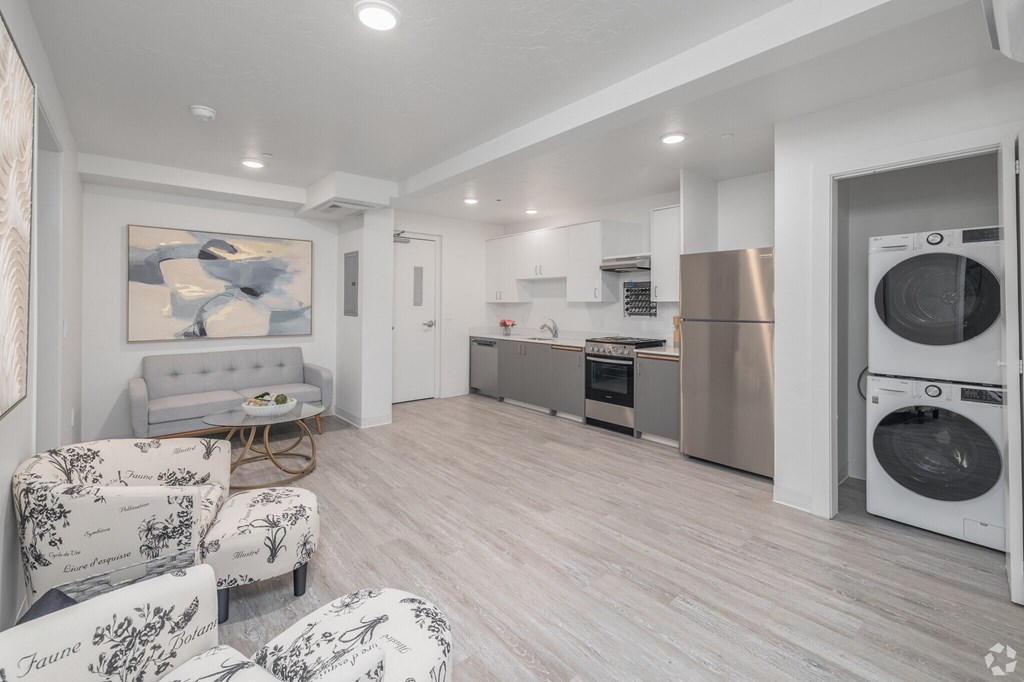 A modern kitchen with a washing machine and dryer built into the cabinetry.