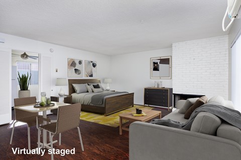 A bedroom with a bed, dresser, and a couch.