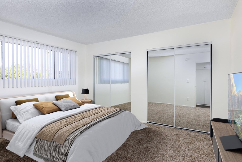 a bedroom with a large bed and a mirrored closet