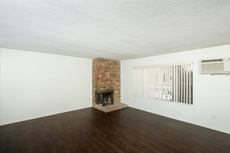 a living room with a brick fireplace and white walls - Photo Gallery