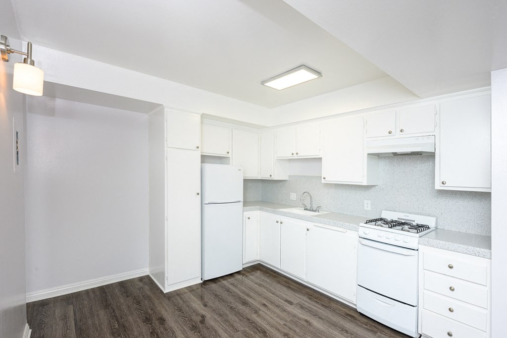 a white kitchen with white appliances and white cabinets