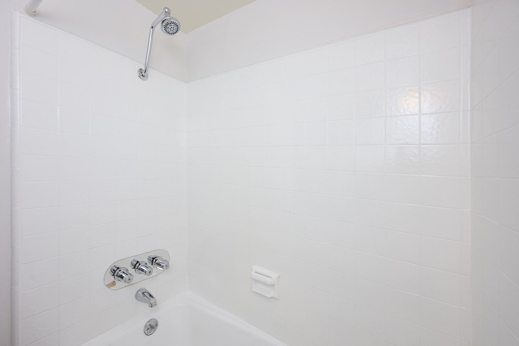 a white bathroom with a shower and a tub