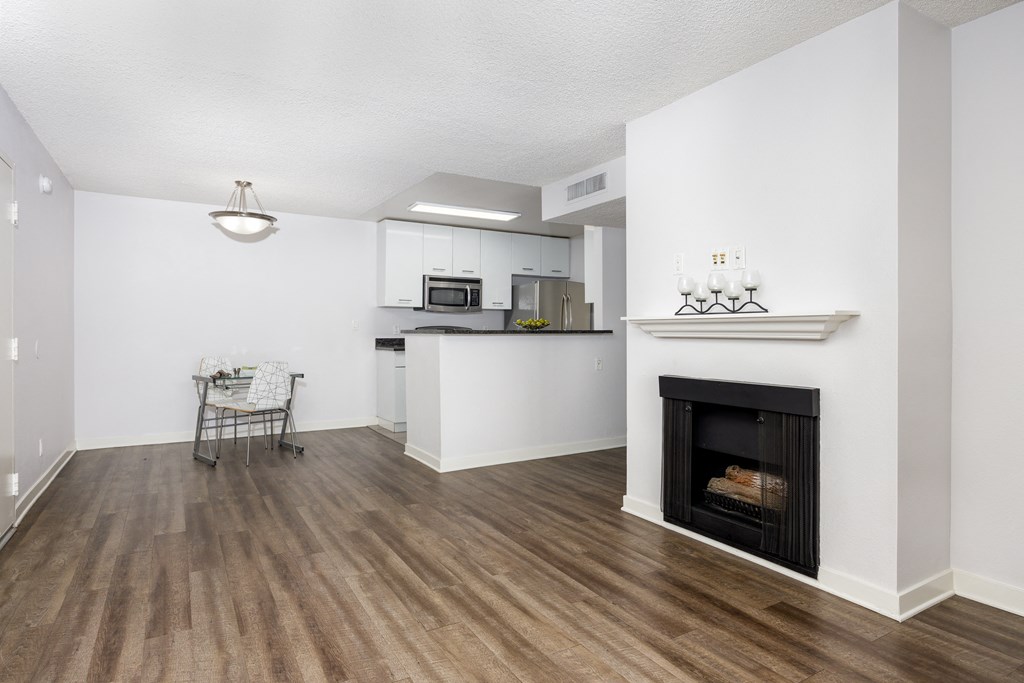 a living room with a fireplace and a kitchen