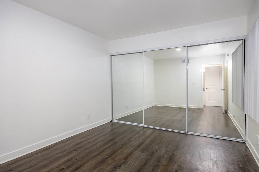 an empty room with white walls and sliding glass doors