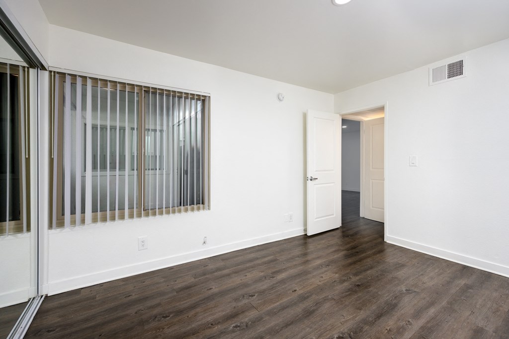 an empty living room with white walls and wood flooring