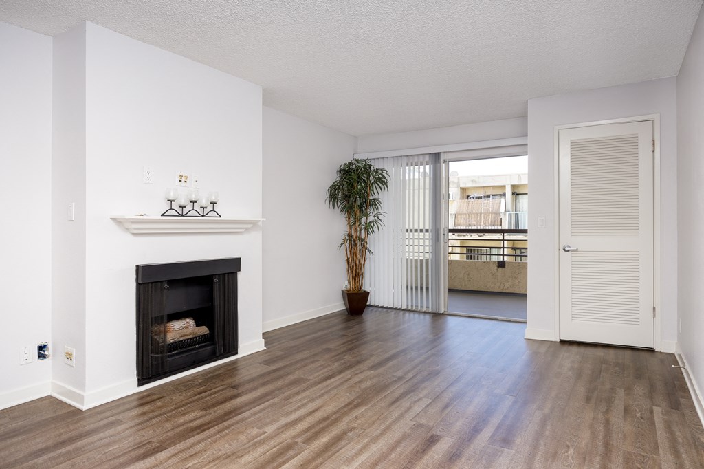 a living room with a fireplace and a door to a balcony