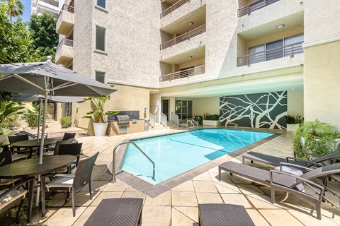 A large outdoor pool area with a table and chairs.