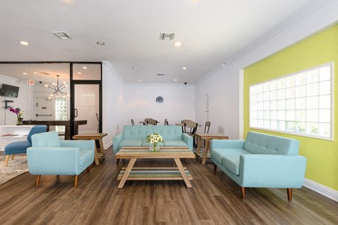 a living room with blue couches and chairs and a table
