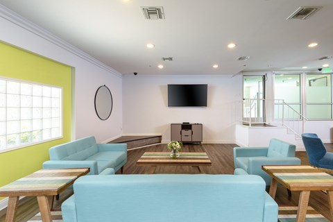 A living room with a blue couch and a flat screen TV.