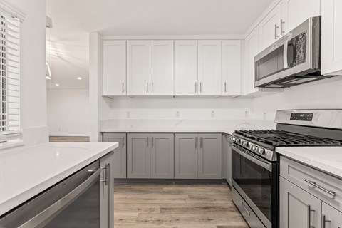 A kitchen with white cabinets and a stainless steel oven.