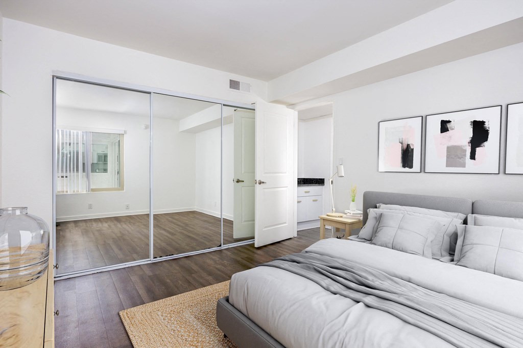 a bedroom with a large bed and a glass closet