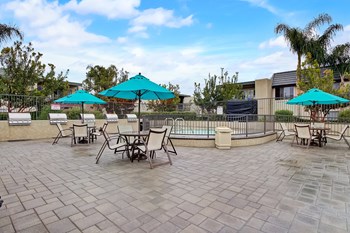 a patio with tables chairs and umbrellas - Photo Gallery 28